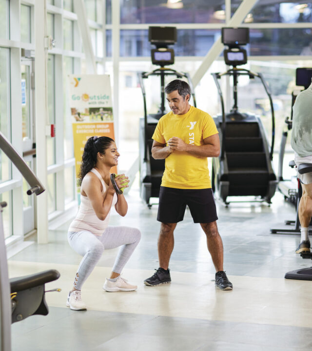 A personal trainer showing a woman how to do squats