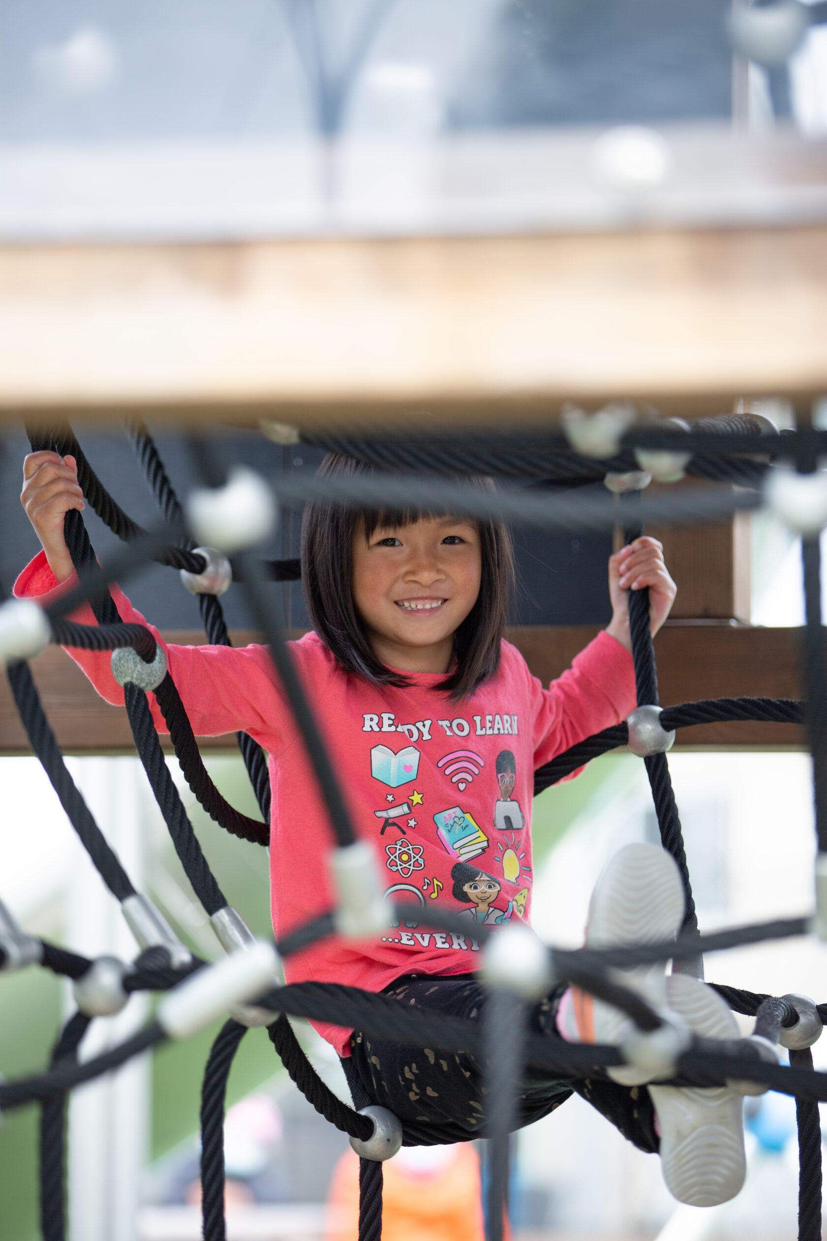 Young girl playing on children's outdoor play structure