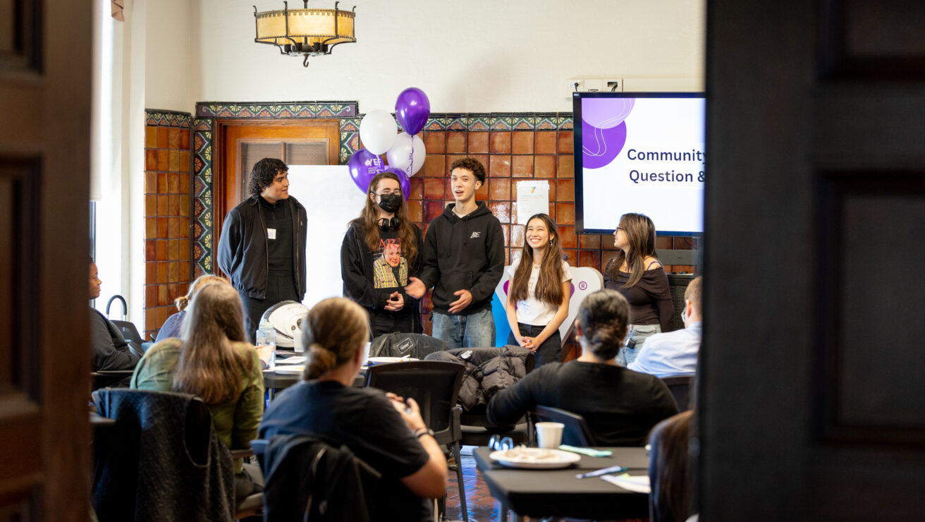 A group of teenagers speaking to a crowd.