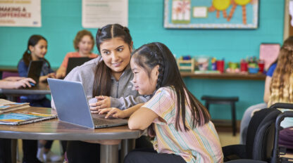 Adult and youth looking at a laptop screen.