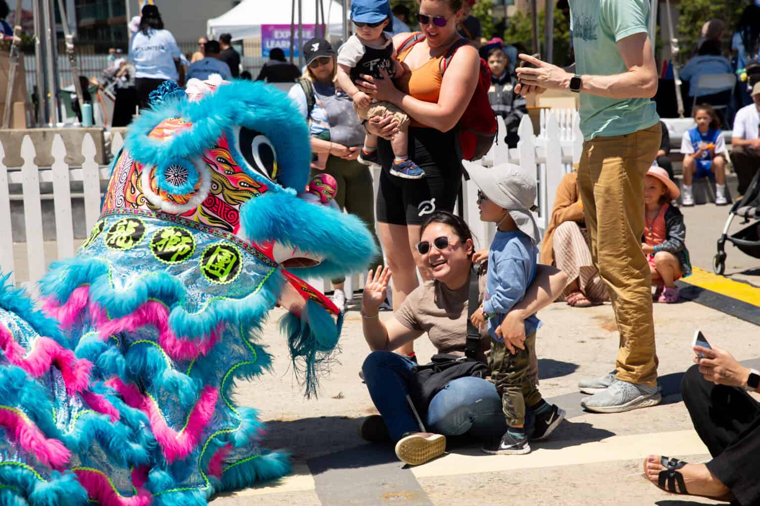 Adult and youth watching a Chinese lion dance performance.