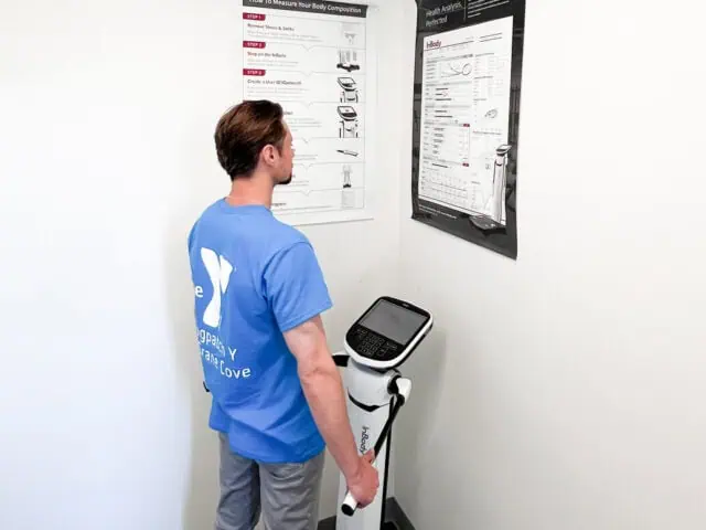 A man standing next to a machine that has a sign on it.