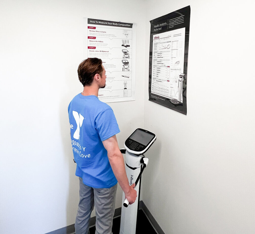 A man standing next to a machine that has a sign on it.