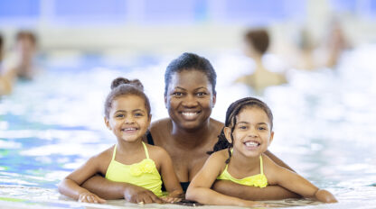 Adult female with two female youth in a swimming pool.