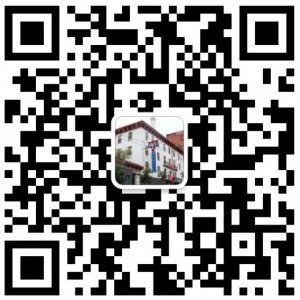 Black-and-white QR code with a small image of a building in the center. The code likely directs users to support services or immigrant assistance offered by the Immigrant Support Center when scanned with a mobile device.